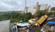 This handout photo taken and released on October 4, 2024 by Taiwanese city councillor Chen Yi shows public utility vehicles trapped in a landslide that was triggered by heavy rainfall after Typhoon Krathon swept across the island near Keelung City's Bureau of Environmental Protection. (Photo by Handout / Taiwanese city councillor Chen Yi / AFP)