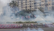 \Supporters of the Optimist Party for the Development of Mozambique (PODEMOS) run from tear gas lobbed at them by units of the Mozambican anti-riot police during a strike called in Maputo, on October 21, 2024. (Photo by ALFREDO ZUNIGA / AFP)
