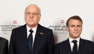 Lebanon's Prime Minister Najib Mikati (L) and France's President Emmanuel Macron pose for a group photo during an international press conference in support of Lebanon, in Paris on October 24, 2024. (Photo by Alain Jocard / POOL / AFP)