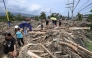 AFP file photo of people walk amongst debris of logs swept away due to heavy rain