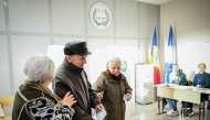 A Moldova's ederly man is helped as he walks to cast his vote for the presidential election at a polling station in Chisinau November 3, 2024. Photo by Daniel MIHAILESCU / AFP.