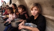 Palestinian children collect aid food at Bureij refugee camp in the central Gaza Strip, on November 6, 2024. (Photo by Eyad BABA / AFP)
