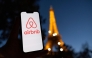 This photograph taken on October 28, 2024 shows the logo of short-term housing rentals online application Airbnb on a smart-phone screen in front of the Eiffel Tower in Paris. Photo by Grégoire CAMPIONE / AFP