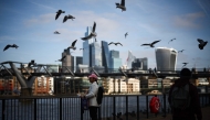 File photo: Seagulls fly over people walking on the Southbank of the River Thames backdropped by the business and financial district in central London on November 15, 2024. Photo by HENRY NICHOLLS / AFP.