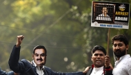 A member of the Indian Youth Congress (IYC) wearing a face cutout of Indian industrialist Gautam Adani takes part in a protest against the businessman, in New Delhi on November 25, 2024. (Photo by Sajjad HUSSAIN / AFP)
