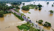 People walk along a street at a neighborhood partially submerged in floodwater as cyclone Fengal is forecasted to make landfall in Puttalam on November 29, 2024. (Photo by AFP)
