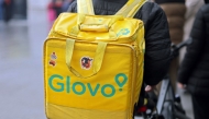 A food delivery firm Glovo's rider carries his bag in Madrid on December 2, 2024. Following a Spanish government pressure, Glovo company in Spain gives to their employees a labour contract. (Photo by Thomas COEX / AFP)
