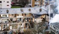 Firemen try to douse a fire following a fire and an explosion at a residential building in The Hague on December 7, 2024. A three-storey apartment block in the Hague partially collapsed December 7, 2024 after a fire and explosion, firefighters said, with first responders searching for people under the rubble. (Photo by Jeffrey GROENEWEG / ANP / AFP) / Netherlands OUT
