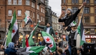 Members of the Syrian community wave Syrian flags on December 8, 2024 in Copenhagen, Denmark, as they rally to celebrate the end of Bashar al-Assad's rule after rebel fighters took control of the Syrian capital Damascus overnight. (Photo by Emil Nicolai Helms / Ritzau Scanpix / AFP) / Denmark OUT
