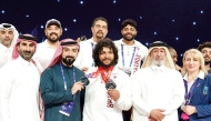 Fares Ibrahim celebrates with Qatar Olympic Committee's First Vice President and Vice President of the International Weightlifting Federation Mohamed bin Yousef Al Mana and Qatar Weightlifting Federation's Secretary General Jassim Ibrahim Al Mansouri. 
