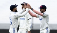 India's Virat Kohli (L) and Nitish Kumar Reddy (R) celebrate the wicket of Australia's Pat Cummins on the second day of the fourth cricket Test match between Australia and India at the Melbourne Cricket Ground (MCG) in Melbourne on December 27, 2024. (Photo by Martin Keep / AFP) 