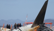 Investigators from South Korea and the US, including officials from the US National Transportation Safety Board (NTSB) and aircraft manufacturer Boeing, inspect the scene where a Jeju Air Boeing 737-800 aircraft crashed and burst into flames at Muan International Airport in Muan, some 288 kilometres southwest of Seoul on December 31, 2024. Photo by YONHAP / AFP