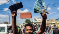 People protest calling upon the army-backed Sudanese government to extend the deadline to exchange Sudanese pound banknotes after authorities reportedly changed two of the notes in circulation, invalidating the old ones, in the northeastern Red Sea city of Port Sudan on December 31, 2024. (Photo by AFP)
