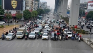 A man rides a motorbike in front of vehicles waiting at a red light at an intersection in Hanoi on January 8, 2025. (Photo by Nhac NGUYEN / AFP)
