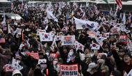 Pro-Yoon supporters wave flags as they gather on a road outside the Seoul Western District Court in Seoul on January 18, 2025. (Photo by Anthony Wallace / AFP)
 