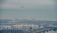 An aeroplane flies over Barcelona's port following an explosion of a tank containing a highly flammable substance in Barcelona on January 21, 2025. (Photo by Manaure Quintero / AFP)
 