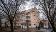 People stand in front of an empty school in Budapest on January 23, 2025 following bomb threats. (Photo by FERENC ISZA / AFP)
