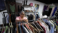 A teacher browses clothes inside a second-hand run by the Venezuelan Teachers' Federation (FVM) in Caracas, on February 17, 2025. (Photo by Pedro Mattey / AFP)
 