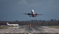 A passenger jet takes off from the single runway as another waits at Gatwick Airport, south of London on February 27, 2025, as the UK Government delay the final announcement on Gatwick's expansion until October. Photo by HENRY NICHOLLS / AFP