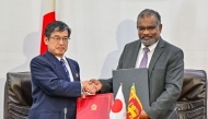 Japan's ambassador to Sri Lanka Akio Isomata (L) and Secretary to Sri Lanka's finance ministry Mahinda Siriwardana shake hands after signing of debt restructuring agreements between two governments in Colombo on March 7, 2025. Photo by Ishara S. KODIKARA / AFP