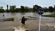 A man crosses flooded waters after a powerful storm struck the city of Bahia Blanca, 600 km south of Argentina's capital, on March 7, 2025. (Photo by PABLO PRESTI / AFP)
