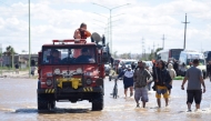People is transported on a police boat through flooded waters the day after a heavy storm in Bahia Blanca, 600 km south of Buenos Aires on March 8, 2025. At least ten people died and more than 1,000 were evacuated in the Argentine port city of Bahia Blanca as torrential rains flooded homes and hospitals, destroyed roads and forced authorities to cut the power. (Photo by PABLO PRESTI / AFP)
