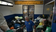 A man walks among donations for people affected by severe flooding in Bahia Blanca, at Club Atletico Atlanta in Buenos Aires on March 10, 2025. (Photo by JUAN MABROMATA / AFP)
