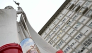 Candles are laid at the statue of John Paul II outside the Gemelli hospital where Pope Francis is hospitalized with pneumonia, in Rome on March 14, 2025. (Photo by Alberto Pizzoli / AFP)