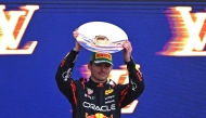 Second-placed Red Bull Racing's Dutch driver Max Verstappen celebrates on the podium with his trophy at the end of the Australian Formula One Grand Prix at Albert Park Circuit in Melbourne on March 16, 2025. (Photo by William West / AFP) 