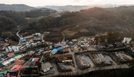 An aerial view shows properties ravaged by wildfires in the coastal village of Nomul-ri in Yeongdeok on March 28, 2025.  (Photo by ANTHONY WALLACE / AFP)