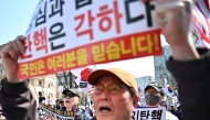 Supporters of impeached South Korean President Yoon Suk Yeol hold placards during a rally on a street in Seoul on April 3, 2025. Photo by Pedro PARDO / AFP