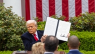 US President Donald Trump shows an executive order on 
