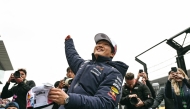 Red Bull Racing's Japanese driver Yuki Tsunoda tosses a cap to the fans during the drivers' parade before the start of the Formula One Japanese Grand Prix at the Suzuka circuit in Suzuka, Mie prefecture, Japan on April 6, 2025. (Photo by MOHD RASFAN / AFP)