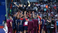 Paris-Saint Germain's players throw up in the air headcoach Luis Enrique as they celebrate after winning the match and the French championship title at The Parc des Princes Stadium in Paris on April 5, 2025. (Photo by Franck Fife / AFP)

