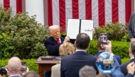 US President Donald Trump shows an executive order on 