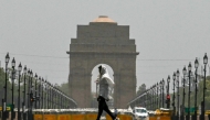A man wears a scarf as he walks past the India Gate on a hot summer day in New Delhi on June 18, 2024. Photo by Arun SANKAR / AFP.