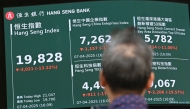A man looks at an electronic sign board showing the closing price of the Heng Seng Index in Hong Kong on April 7, 2025. Photo by Peter PARKS / AFP.