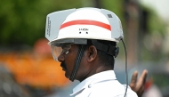 A traffic policeman uses an air-conditioned helmet to get respite from the heat while working at a road junction on a hot summer day in Chennai on April 8, 2025. Photo by R.Satish BABU / AFP