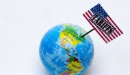This photograph taken in Paris on April 8, 2025 shows a globe with a USA flag with the inscription 