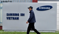 This photo taken on April 8, 2025 shows a man walking past the logo of Samsung Electronics on a billboard in Bac Ninh province. (Photo by Nhac Nguyen / AFP) 