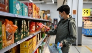 A man buys products in a supermarket in Beijing on April 10, 2025. (Photo by Pedro PARDO / AFP)
