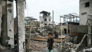 A boy stands among the debris of buildings damaged in a fire in Mandalay on April 11, 2025, following the devastating March 28 earthquake. (Photo by Sai Aung Main / AFP)
