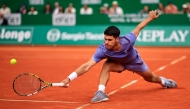 Spain's Carlos Alcaraz plays a backhand return to Spain's Alejandro Davidovich Fokina during the Monte Carlo ATP Masters Series Tournament semi-final tennis match at the Monte Carlo Country Club in Roquebrune-Cap-Martin on April 12, 2025. (Photo by Valery HACHE / AFP)
