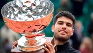 Spain's Carlos Alcaraz celebrates with the trophy after winning against Italy's Lorenzo Musetti the Monte Carlo ATP Masters Series Tournament final tennis match at the Monte Carlo Country Club in Roquebrune-Cap-Martin on April 13, 2025. (Photo by Valery HACHE / AFP)