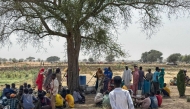 People who fled the Zamzam camp for the internally displaced after it fell under RSF control, gather for communal cooking in a makeshift encampment in an open field near the town of Tawila in war-torn Sudan's western Darfur region on April 13, 2025. (Photo by AFP)

