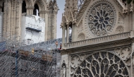 (Files) Workers operate on scaffoldings during reconstruction works around the wooden structure of the Notre-Dame de Paris Cathedral, in Paris on July 4, 2024. (Photo by Joel Saget / AFP)