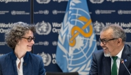 A handout photograph taken and released by the World Health Organisation (WHO) on April 16, 2025 shows Co-chair of the negotiations and French ambassador for Global Health Anne-Claire Amprou (L) and WHO Director-General Tedros Adhanom Ghebreyesus after a consensus on the Pandemic Agreement at the WHO headquarters. (Photo by Christopher Black / World Health Organization / AFP)