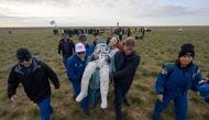 This handout picture courtesy of NASA shows NASA astronaut Don Pettit (C) being carried to a medical tent shortly after he landed in their Soyuz MS-26 spacecraft on April 20, 2025. (Photo by Bill Iingalls / NASA / AFP) 