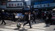 A man runs with a trolley at the Dongmyo Flea Market in Seoul on April 15, 2025. (Photo by ANTHONY WALLACE / AFP)
