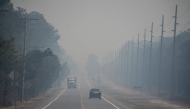 Smoke from the Jones Road Fire covers a road near Lacey Township in Ocean County, New Jersey, on April 23, 2025. (Photo by Matthew Hatcher / AFP)